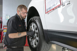 mechanic fixing tire on lifted vehicle