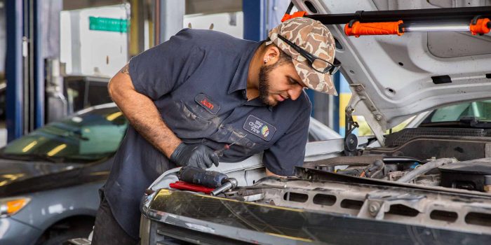 BCT employee works on interior of vehicle engine